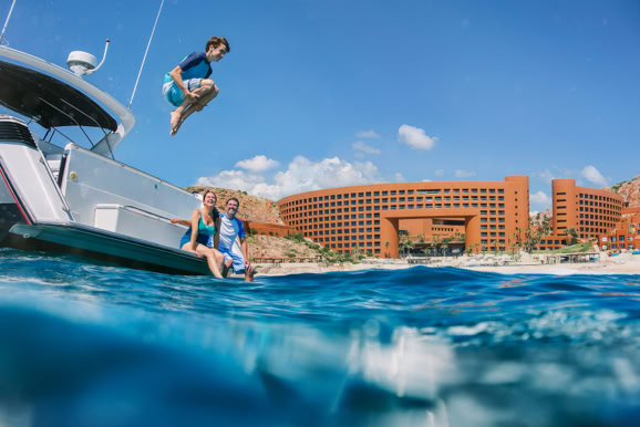 High-energy lifestyle imagery capturing guests diving and enjoying water activities at a resort destination.