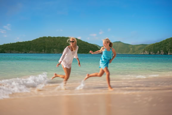 Lifestyle imagery of guests walking along the shoreline, highlighting destination and freedom of travel.